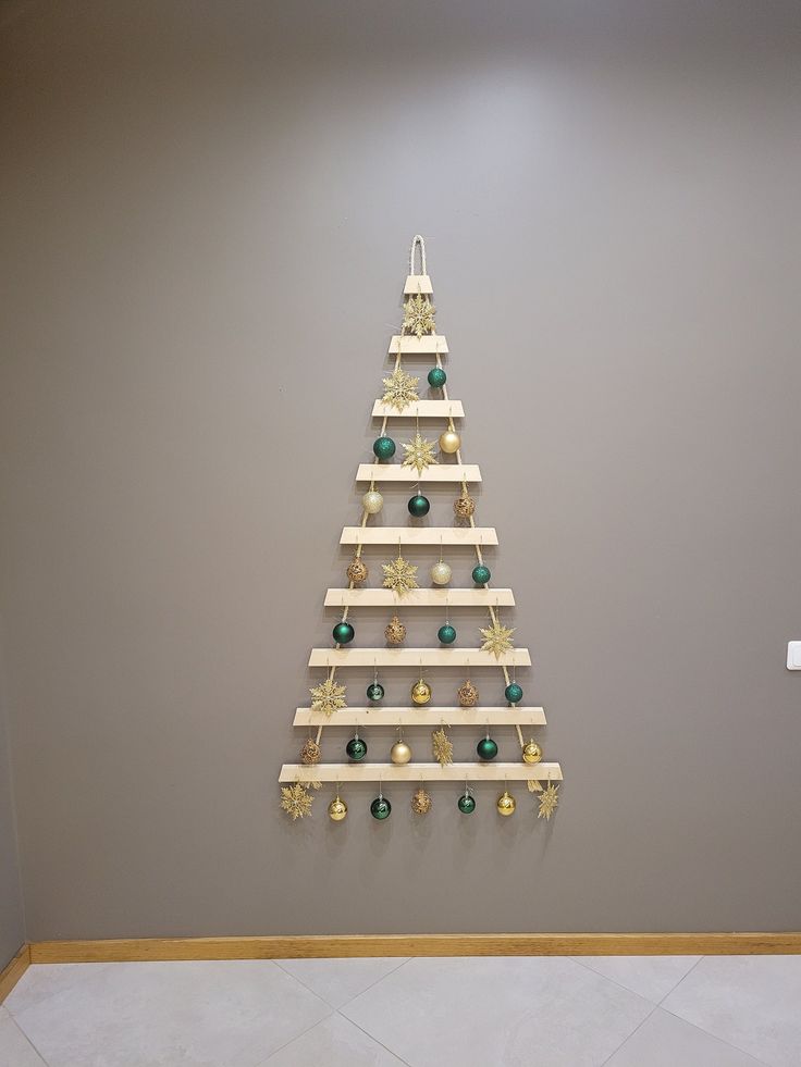 a wooden christmas tree hanging on the wall