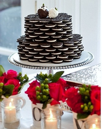 a cake made out of cookies sitting on top of a table next to vases filled with flowers