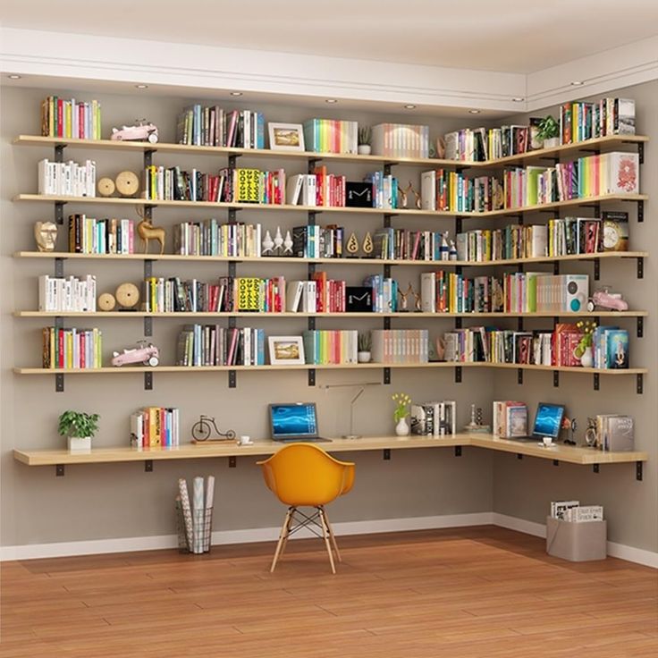 an empty room with bookshelves and a yellow chair in the corner on the hard wood floor