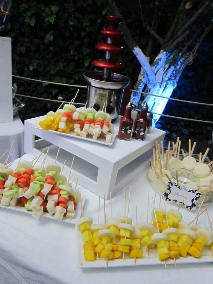 a table topped with lots of food on top of a white tablecloth covered table