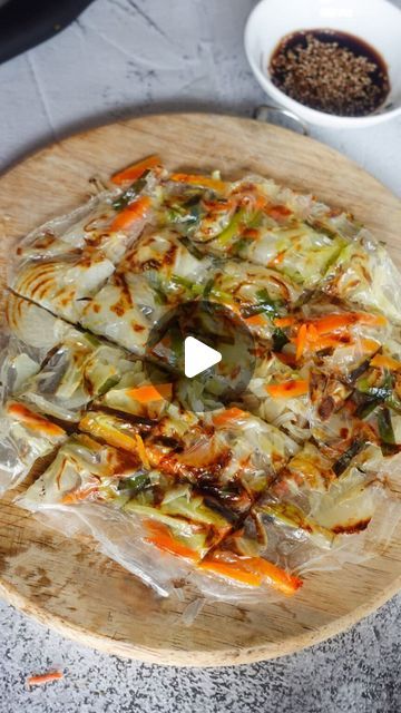 a pizza sitting on top of a wooden cutting board next to a bowl of food