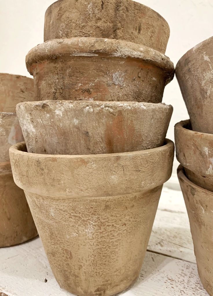 a group of clay pots sitting on top of a white wooden table next to each other