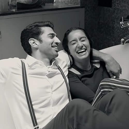 a man and woman sitting next to each other on a couch smiling at the camera