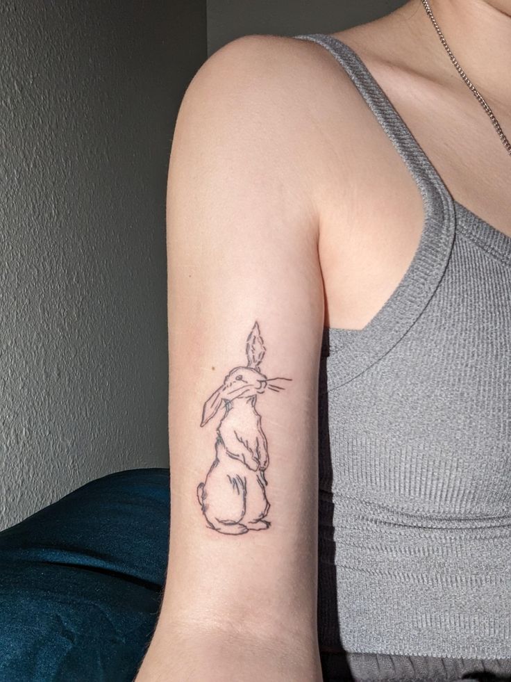 a woman with a rabbit tattoo on her arm