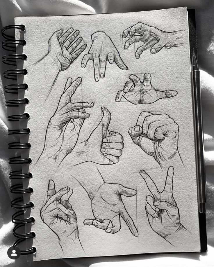 an open notebook with drawings of hands on it