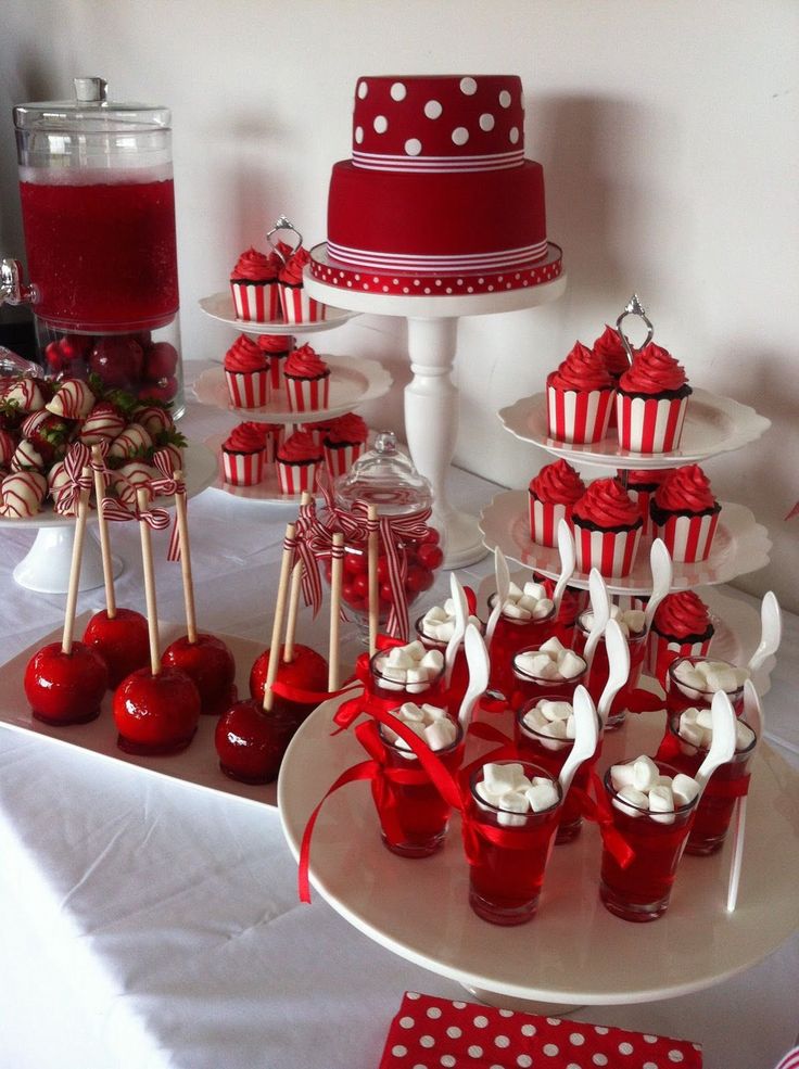 a table topped with lots of red and white desserts