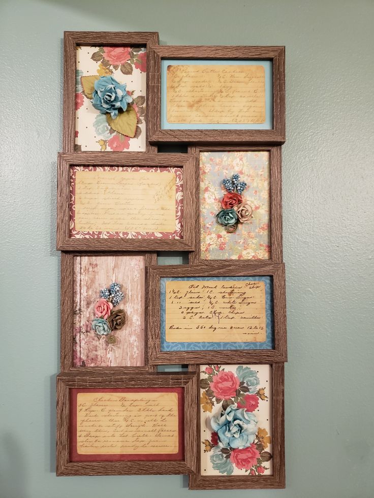 several framed pictures are hanging on the wall with paper flowers and writing in wooden frames