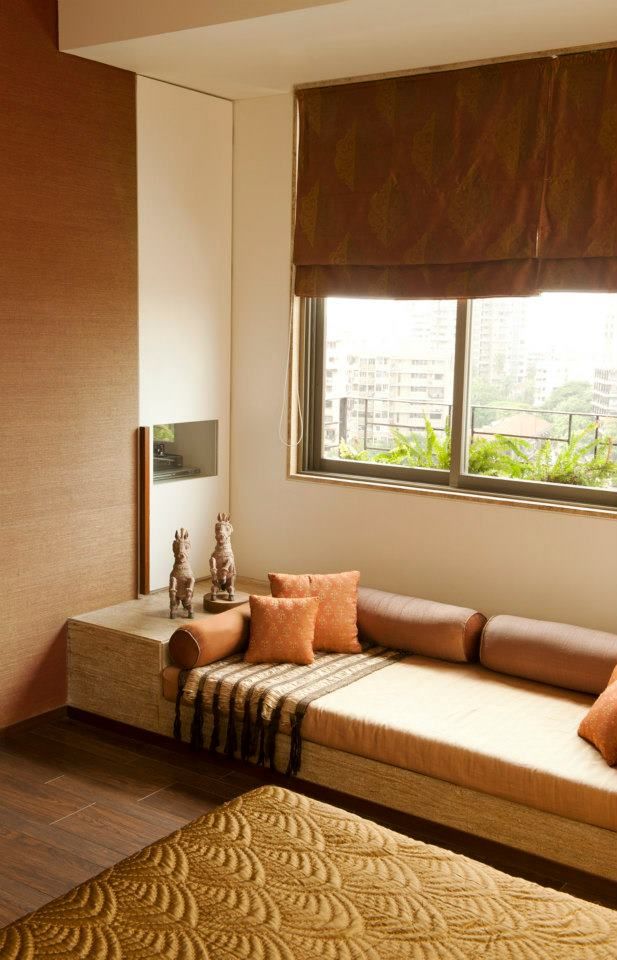 a living room filled with furniture and a large window covered in brown shades next to a wooden floor