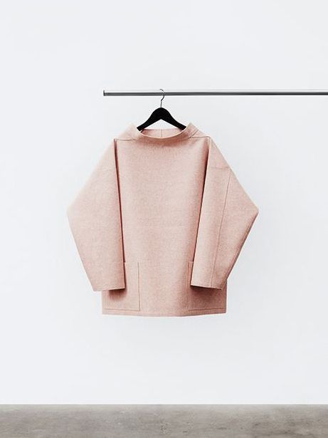 a pink sweater hanging on a clothes line in front of a t - shirt hanger