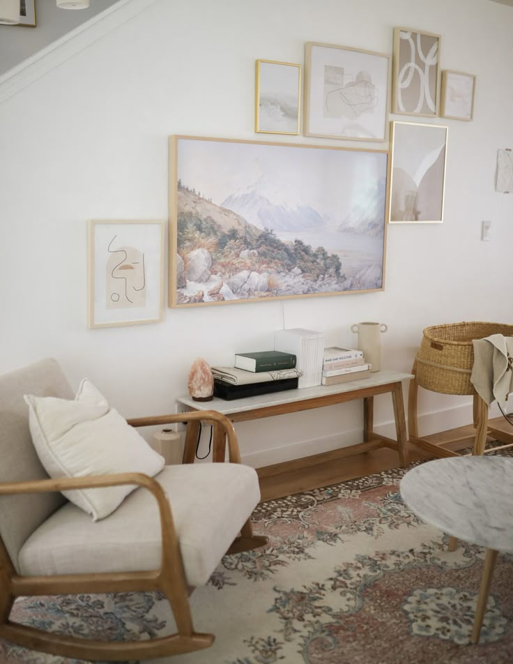 a living room with pictures on the wall and a chair next to a coffee table