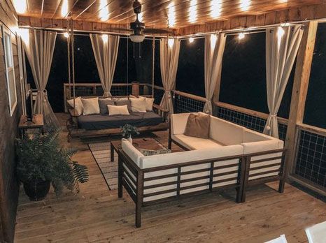 an outdoor living area with couches and lights