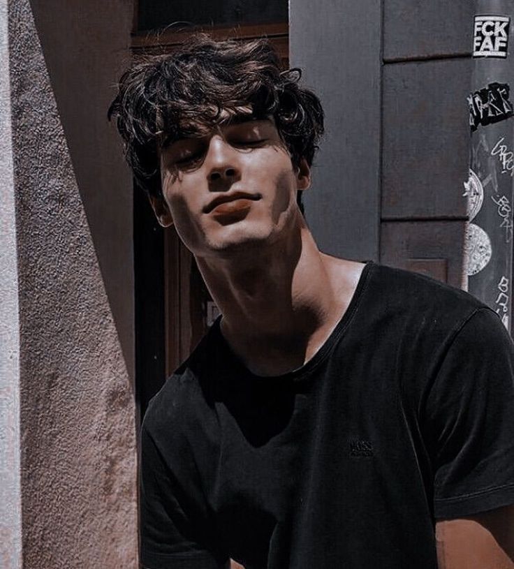 a young man standing in front of a building