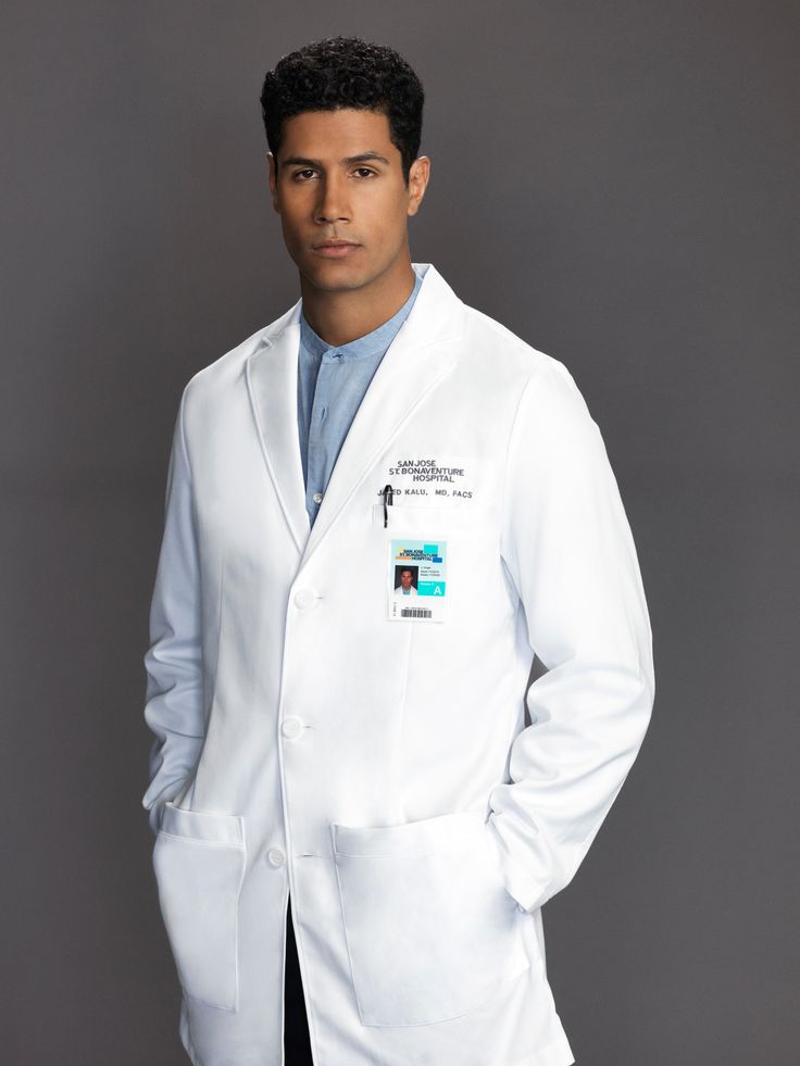 a man in a white lab coat posing for a photo with his hands on his hips