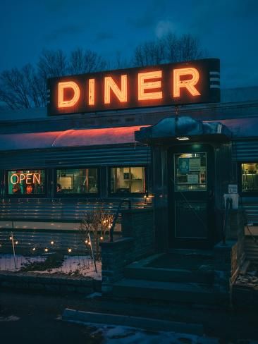 a diner sign lit up in the dark