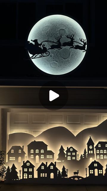 the silhouettes of santa claus and his sleigh are projected in front of a window