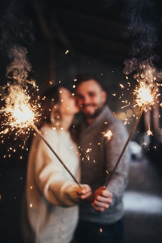 a man and woman holding sparklers in their hands