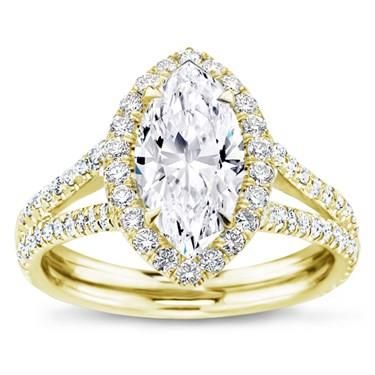 a yellow gold engagement ring with a pear shaped diamond center and pave set shoulders