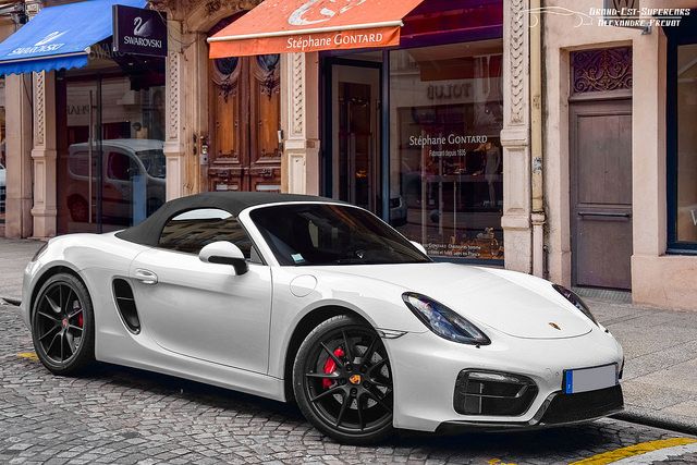 a white sports car parked in front of a store