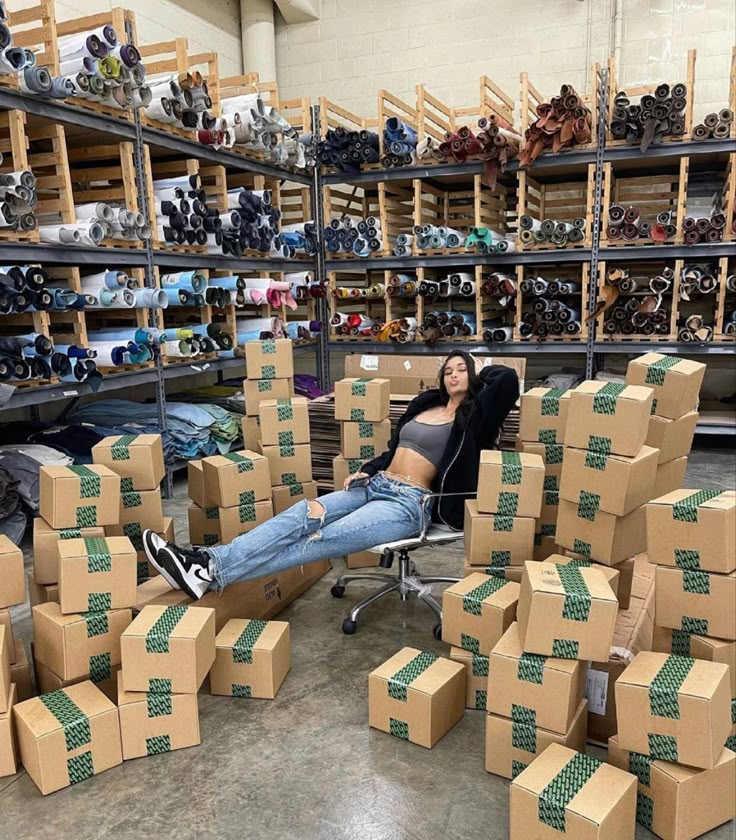 a woman sitting in a chair surrounded by boxes