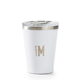 a white tumbler cup with the letter m in gold foil on it's side