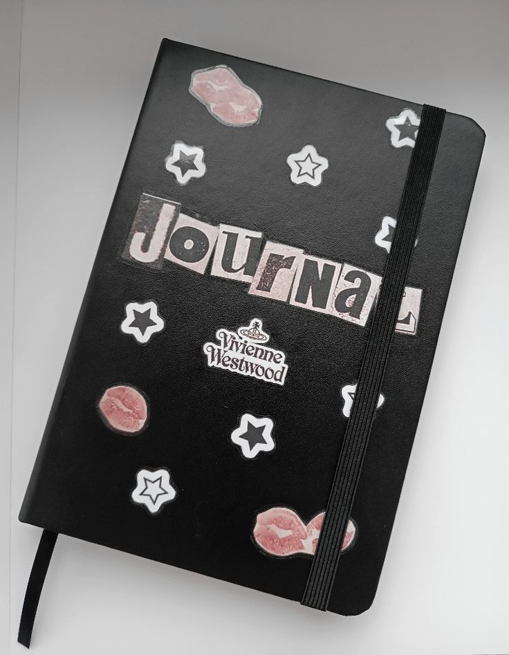 a black journal with pink and white stickers on it