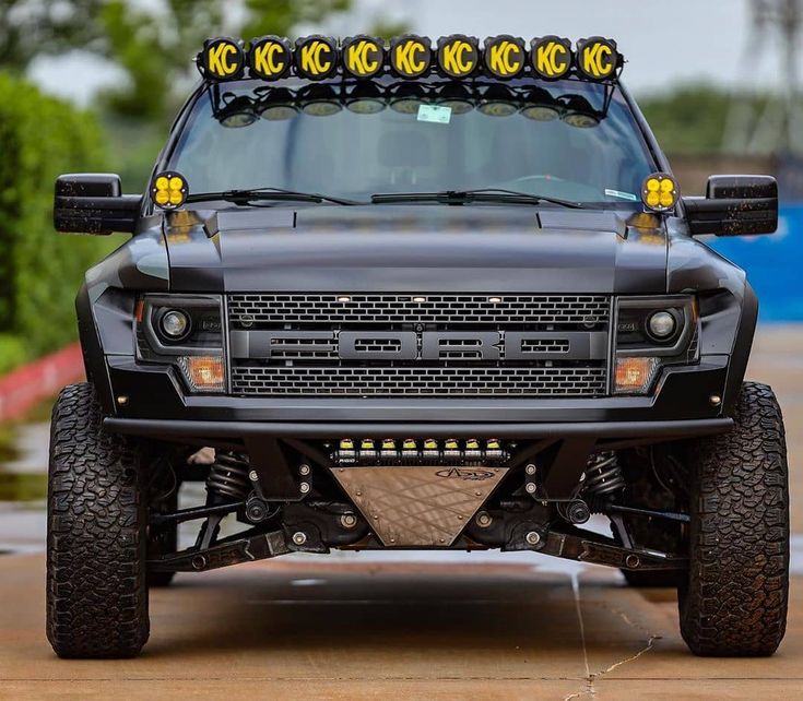 the front end of a black truck with yellow lights