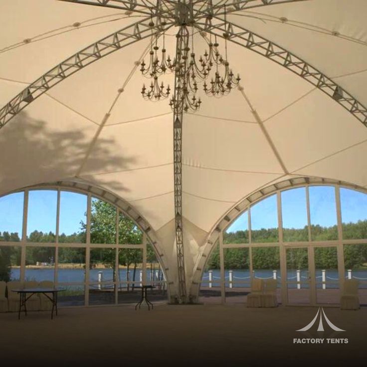 a large white tent with chandelier hanging from it's ceiling and windows