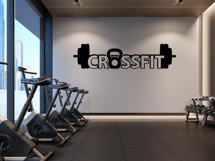 there is a wall sign that says crossfit in the middle of a gym