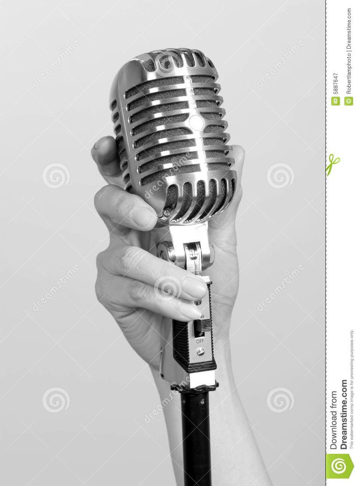 a woman's hand holding an old fashioned microphone in black and white stock photo