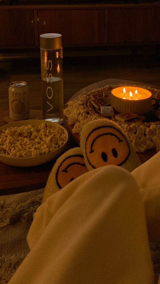 two stuffed animals are sitting on the floor next to a bowl of cereal and a lit candle