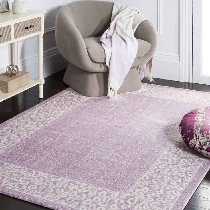 a living room with a chair and rug on the floor