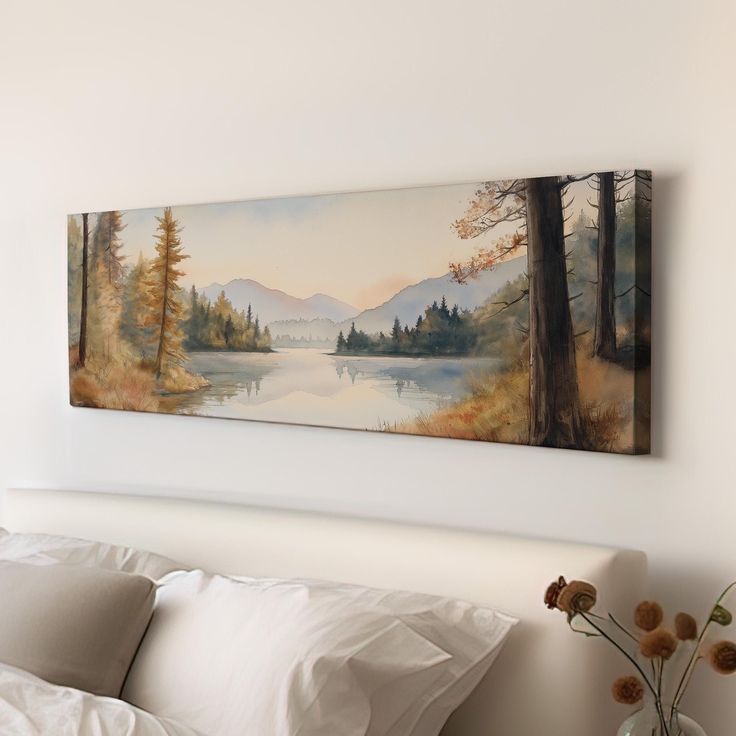 a painting hanging on the wall above a bed in a room with white sheets and pillows