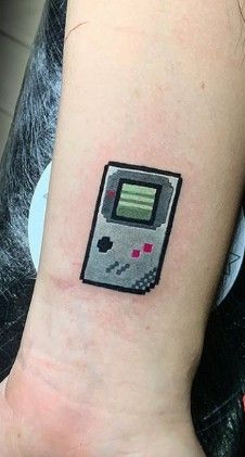 a small tattoo on the wrist of a woman's arm with an old - fashioned computer