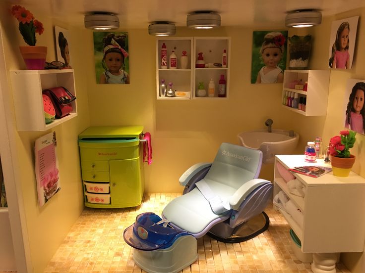 a dollhouse bathroom with an electric chair and shelves filled with dolls in the corner