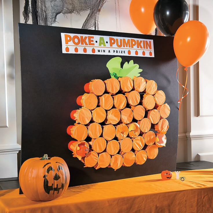 a pumpkin made out of orange slices sitting on top of a table next to balloons