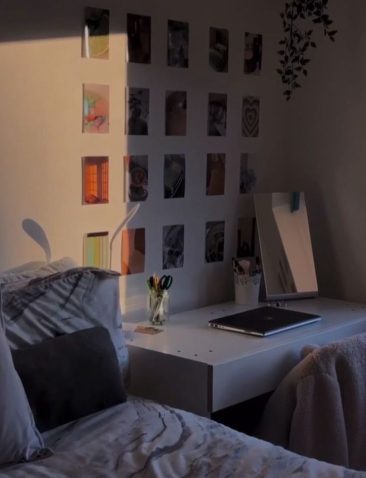 a bedroom with a bed, desk and pictures on the wall above it's headboard