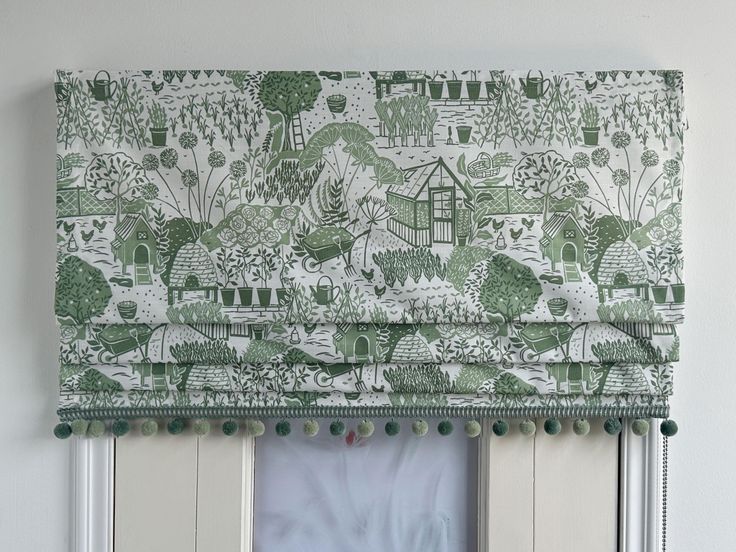 a green and white window valance hanging on the side of a wall