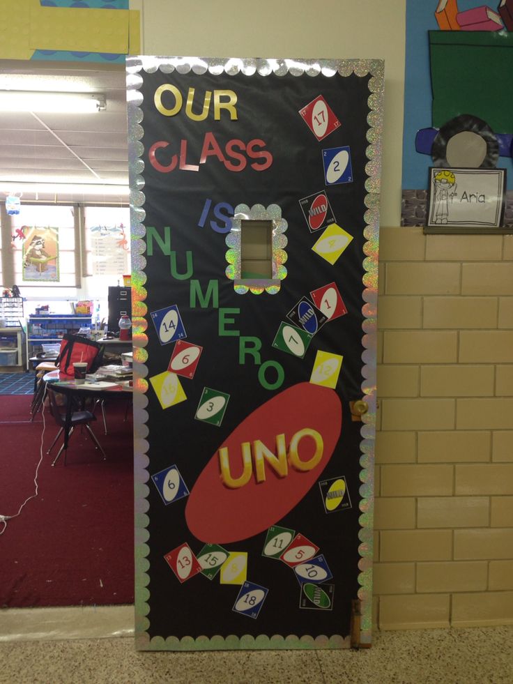 a classroom door decorated with magnets and writing that says our class is number zero uno