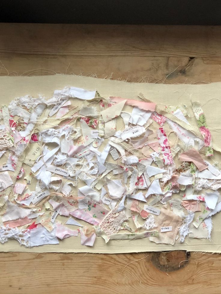 a pile of torn up papers sitting on top of a piece of paper next to a wooden table