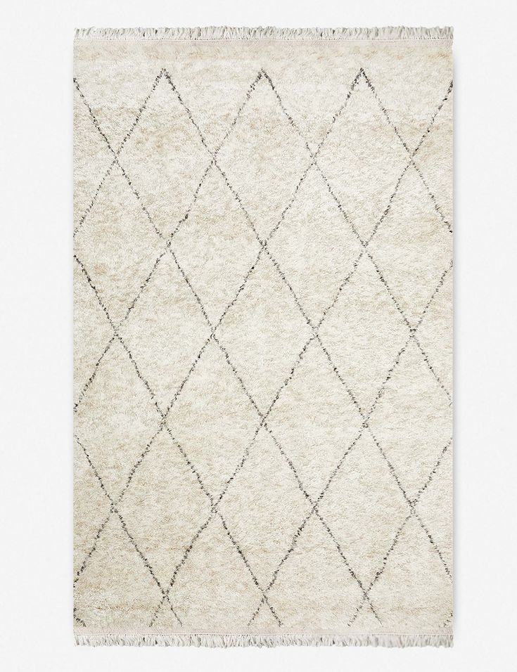 a white rug with diamond shapes on the top and bottom, it is made out of wool