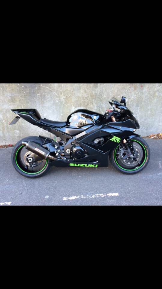 a black motorcycle parked next to a wall