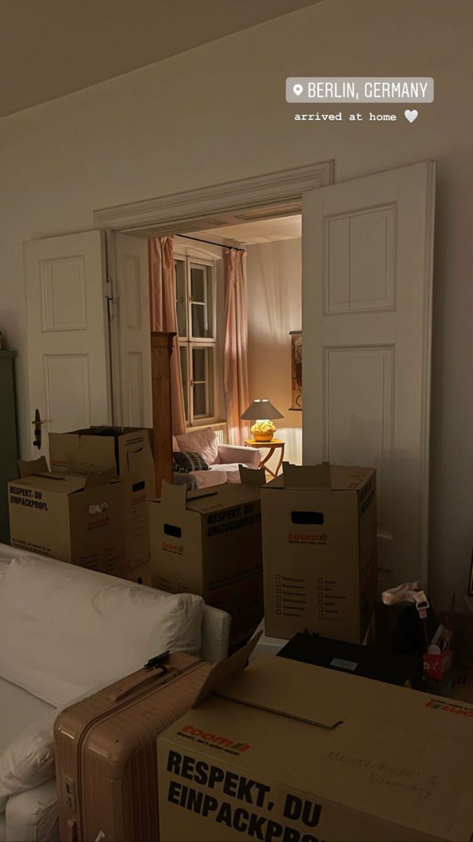 boxes are stacked on top of each other in a room with a bed and dresser