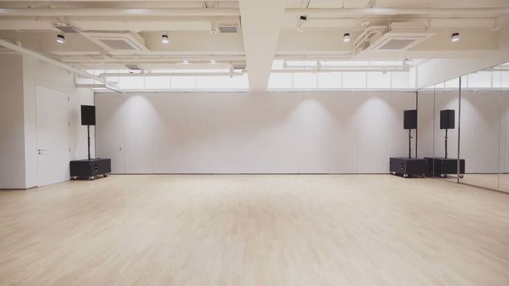 an empty room with speakers on the wall