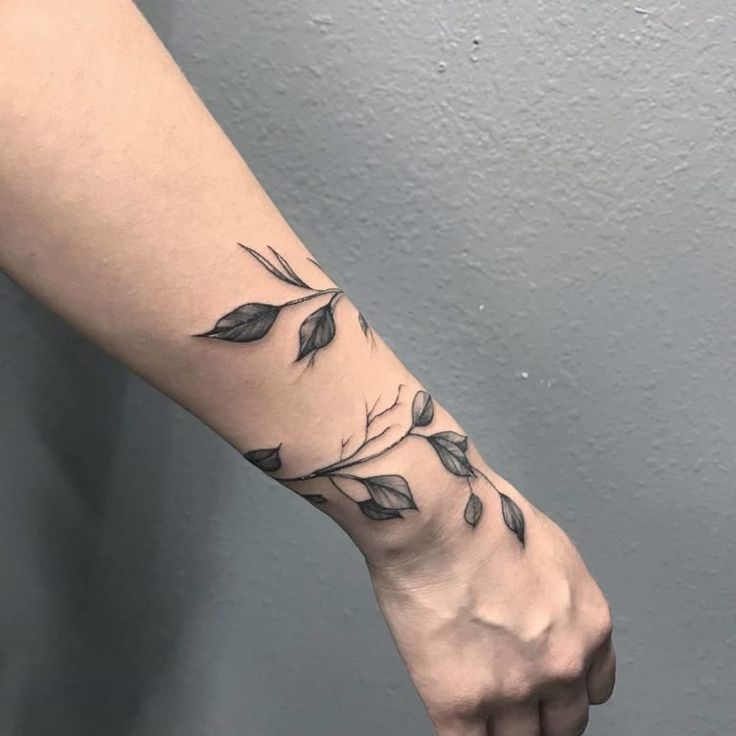 a woman's arm with leaves on it