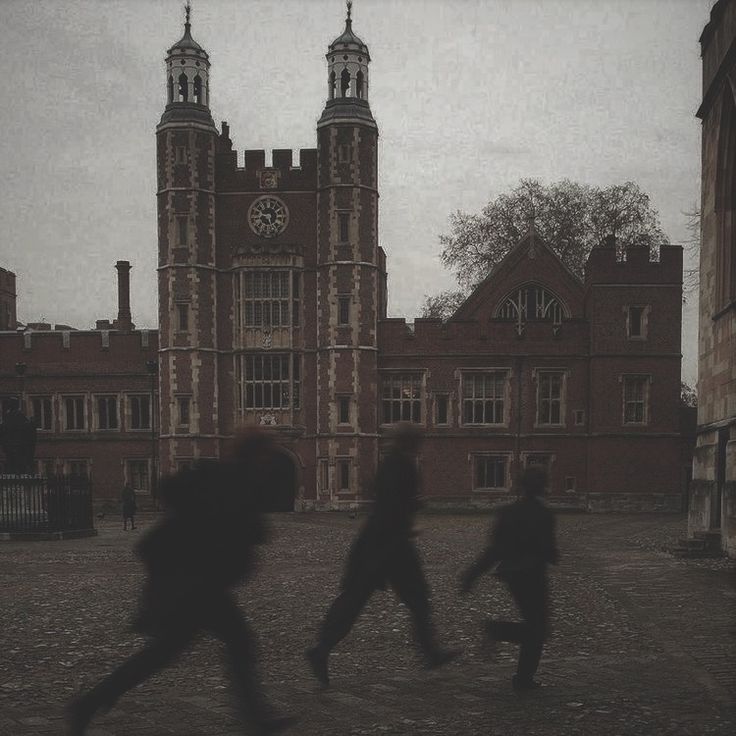 three people are running in front of a building