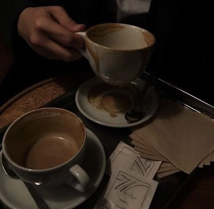 two cups of coffee sitting on top of a table