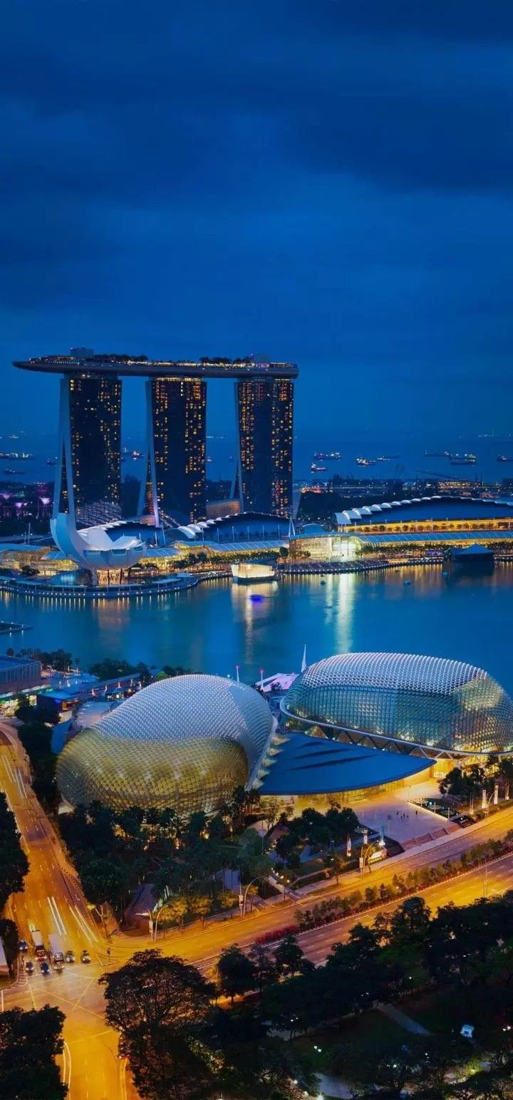 an aerial view of the marina bay area in singapore at night with its lights on