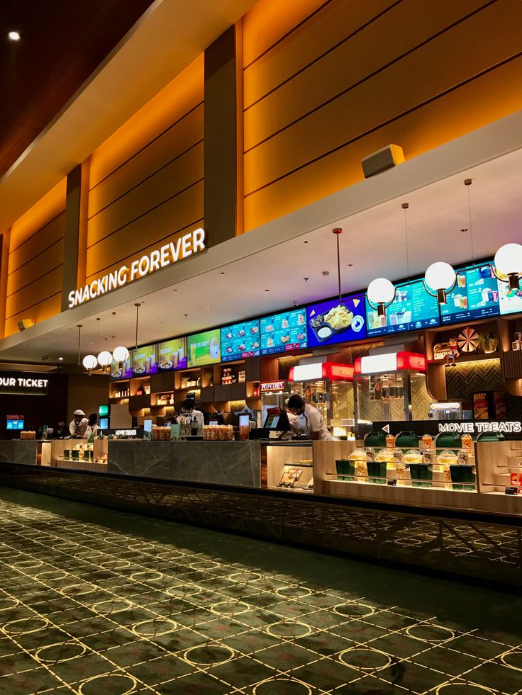 a food court filled with lots of counter space and people sitting at the bar in front of it