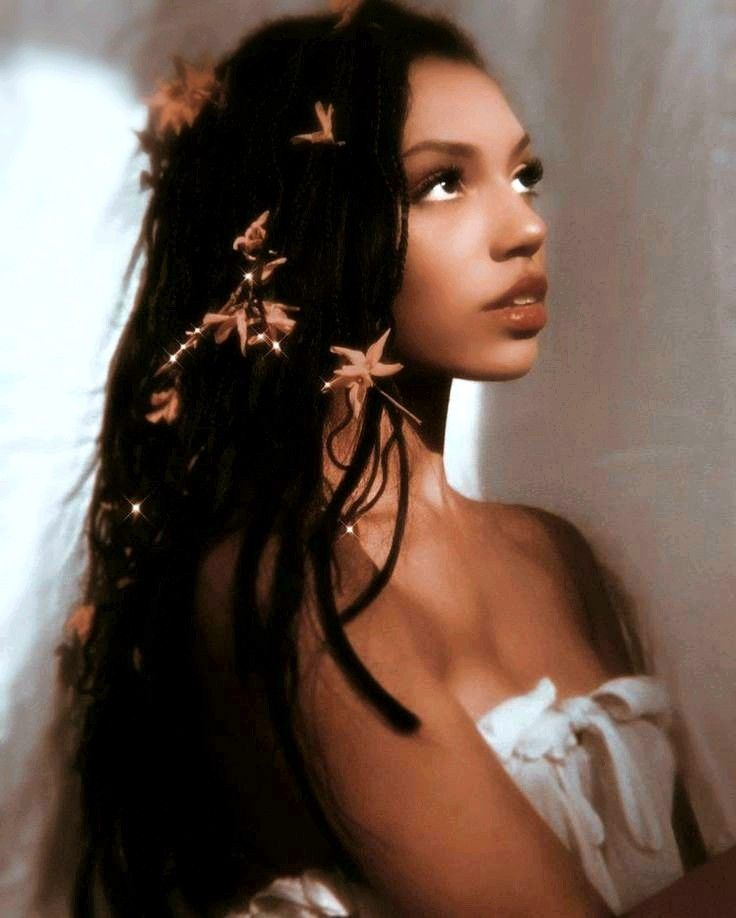 a woman with long black hair and flowers in her hair, wearing a white dress