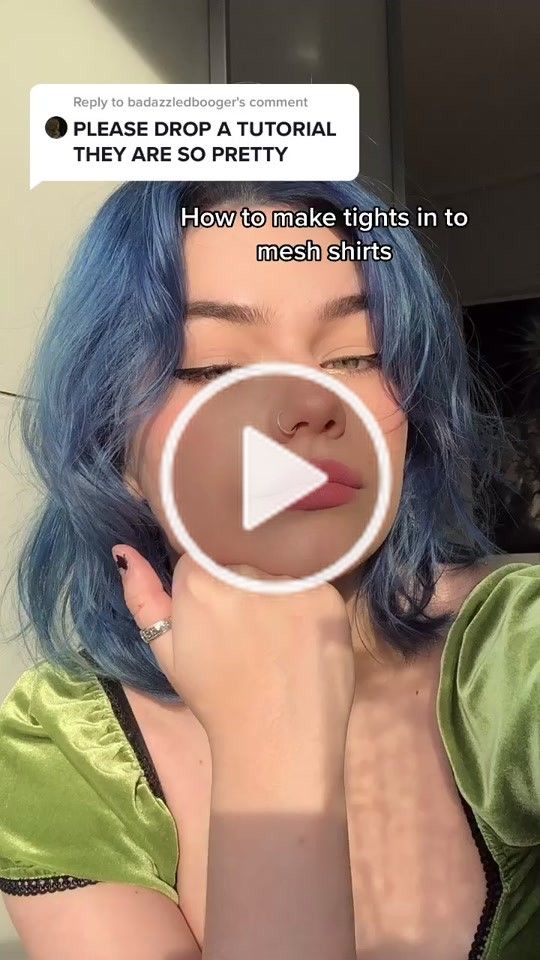 a woman with blue hair is looking at the camera